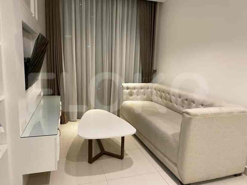 Cozy living space with a tufted sofa, TV, and coffee table.