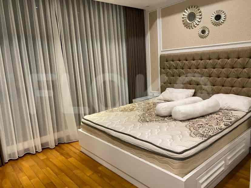 Elegant bedroom featuring a large bed with a tufted headboard and wood flooring.