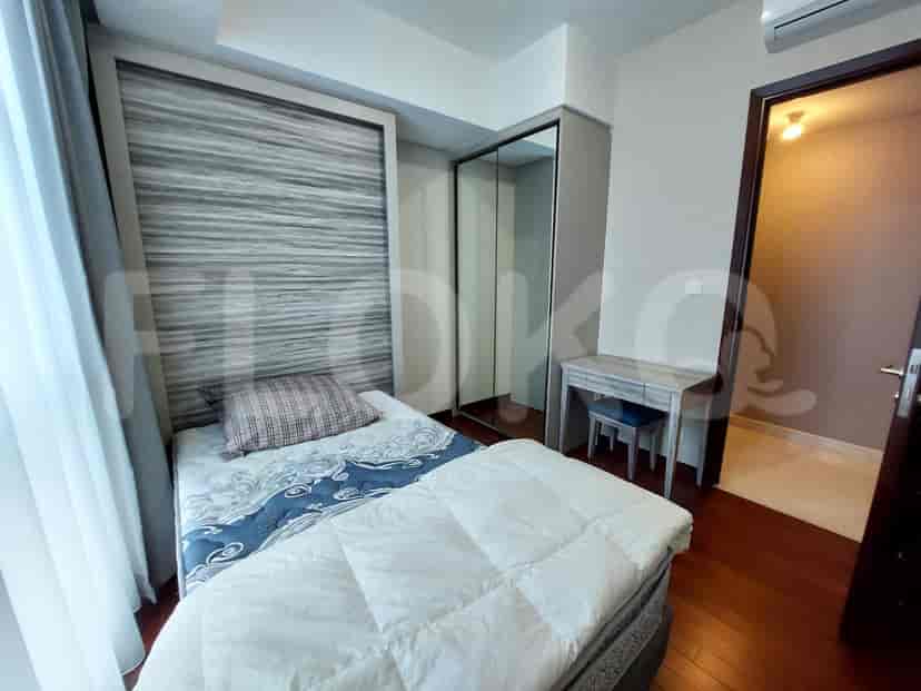 Kamar tidur dengan tempat tidur, lemari pakaian, dan meja.