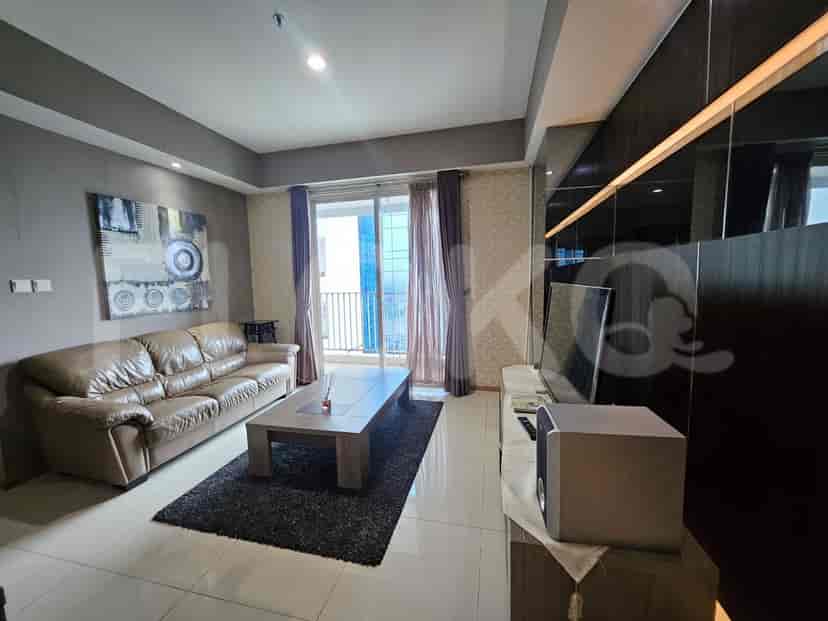 A living room with a leather sofa, a coffee table, and a TV.