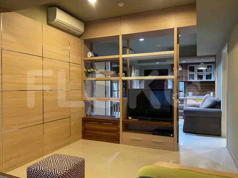 A living room featuring a wall-mounted TV and built-in storage.