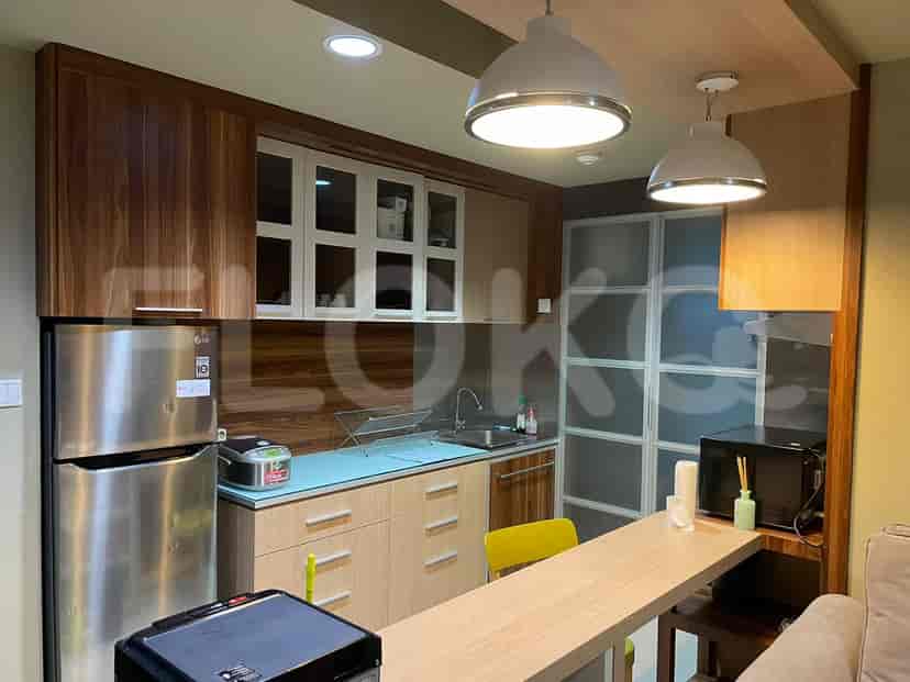 A modern kitchen with wooden cabinets and a stainless steel refrigerator.