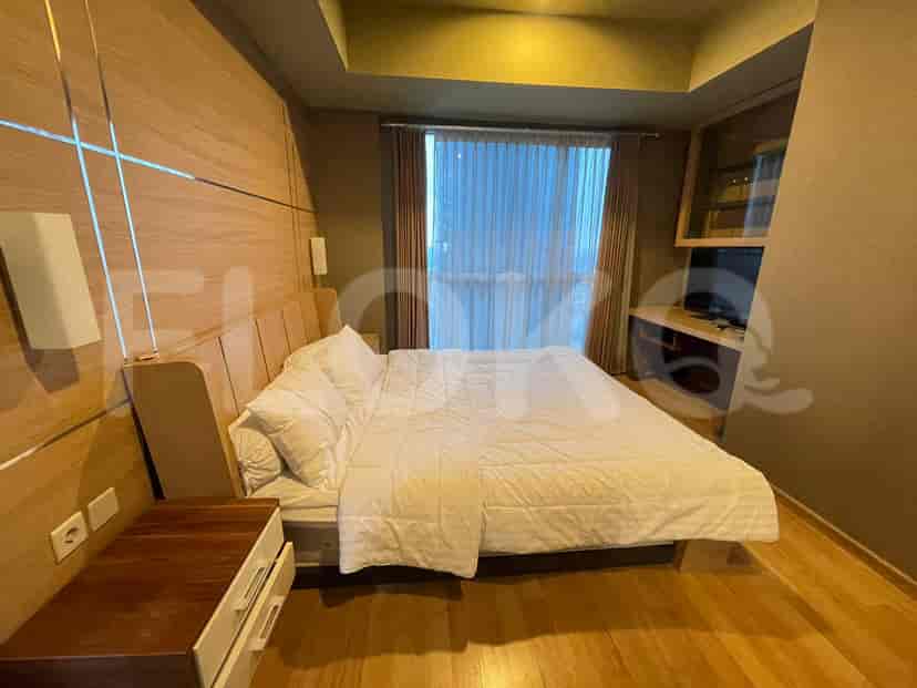 A modern bedroom with a bed, nightstands, and large windows.