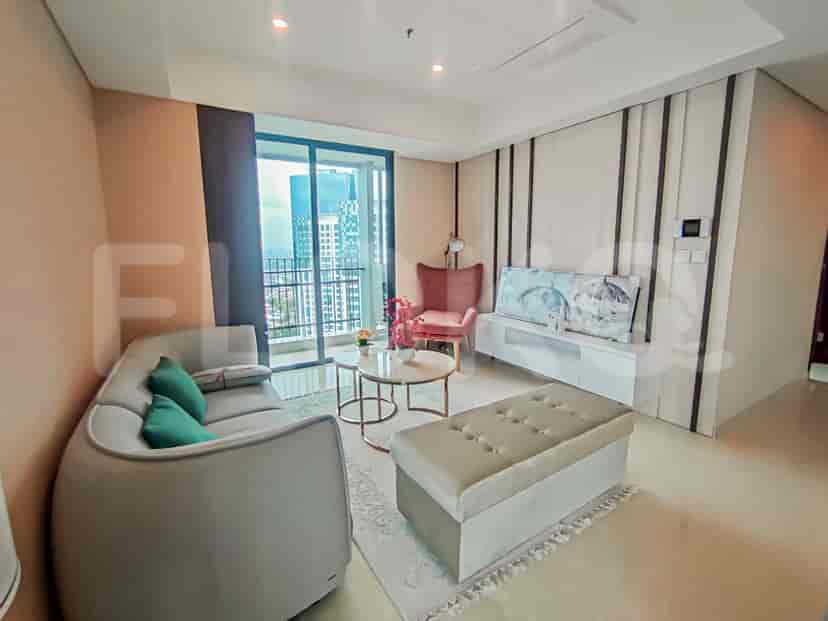 Living room with a large sofa, coffee tables, and a dining area in the back.