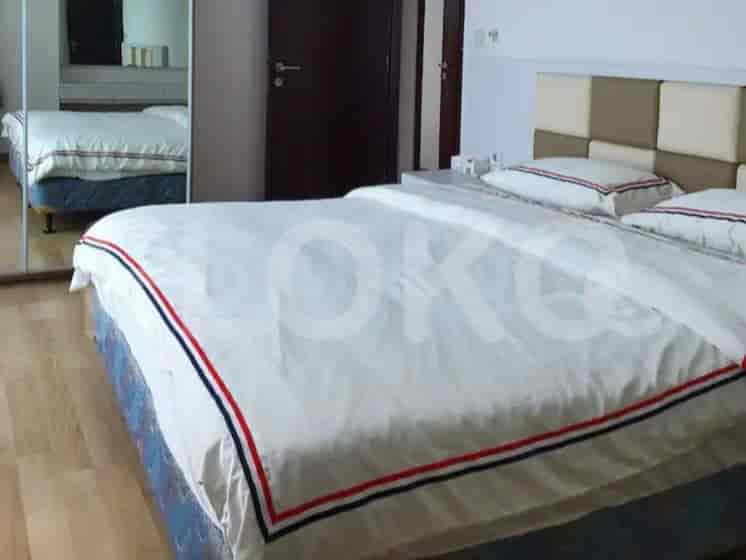 A bedroom with a king-sized bed and a mirror.