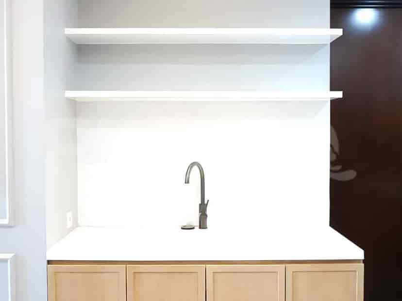 Kitchen with shelves, a sink, and a white countertop.