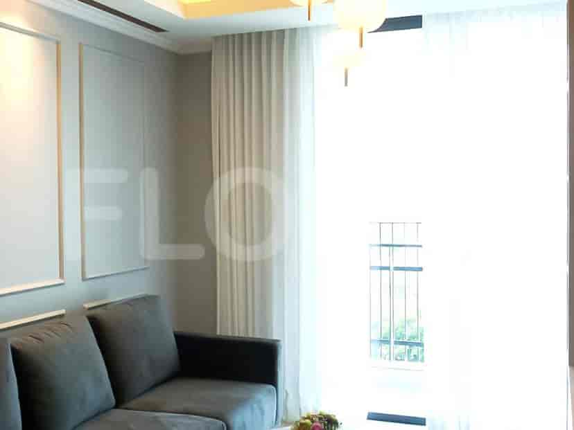 Spacious living room with grey sofa, large window with curtains and a decorative wall panel.