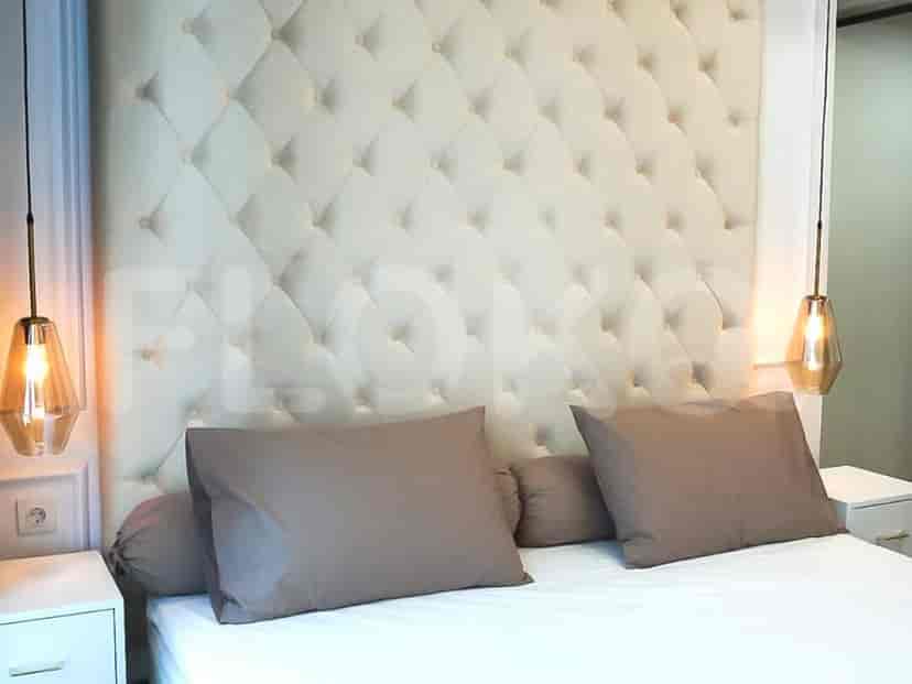 Bedroom with a large bed, tufted headboard, bedside lamps, and a nightstand.