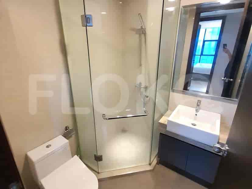 A modern bathroom featuring a glass shower and a toilet.