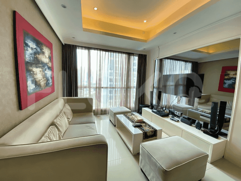 A modern living room with a light-colored sofa, large window, and wall-mounted TV.
