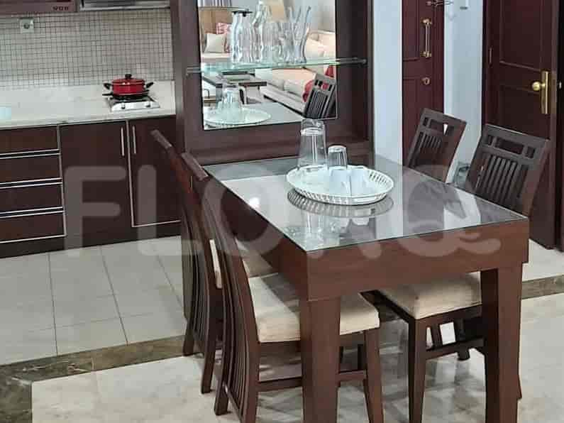 Dining area with a glass-topped dining table and four chairs.