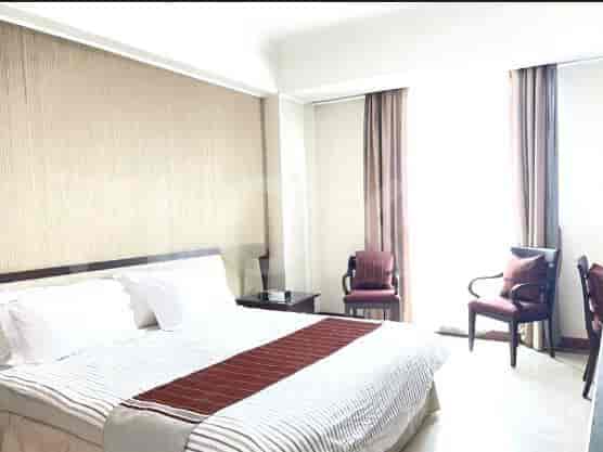 Bedroom with a bed, curtains, and a chair.