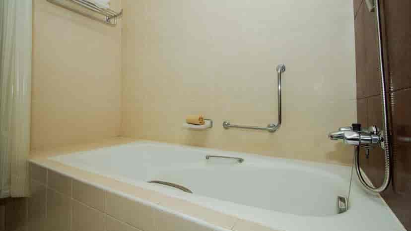 A bathroom with a bathtub and a neutral color scheme.