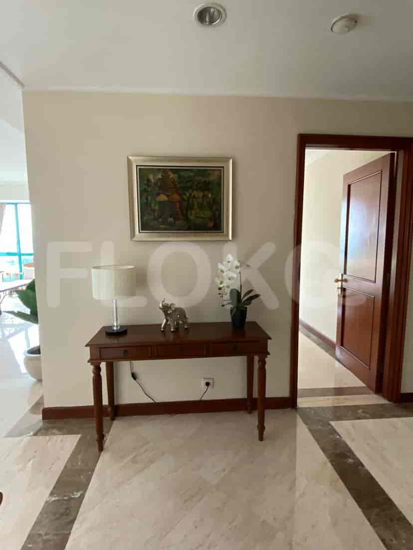 Elegant entryway with a console table, artwork, and marble flooring.