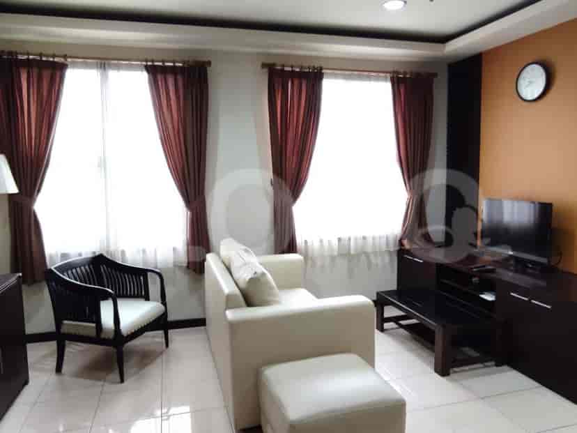 Living room area with a sofa, TV, and a dining area.