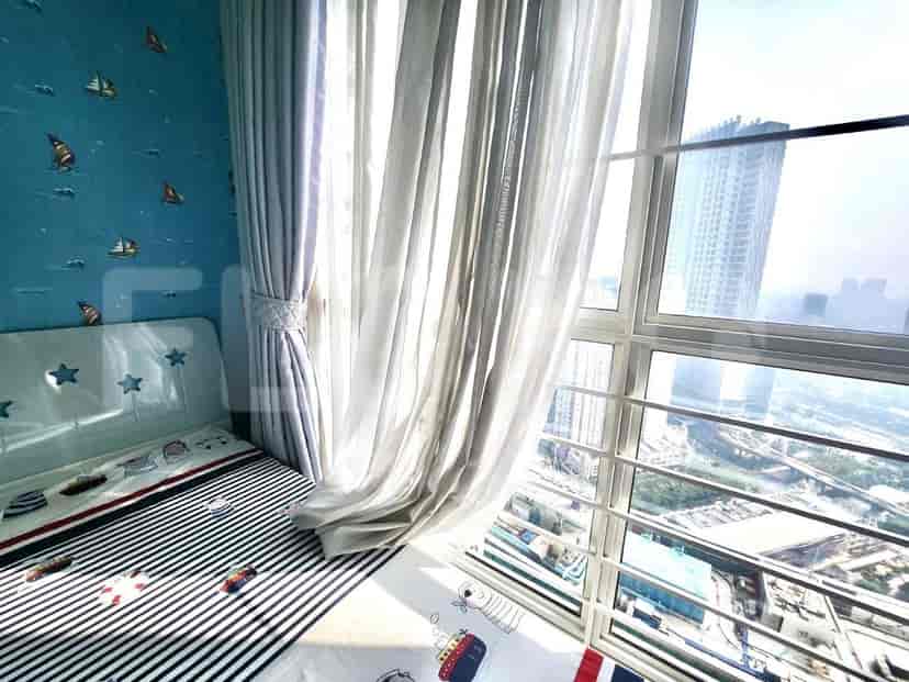 Kamar anak dengan tempat tidur single, wallpaper biru, dan jendela besar.