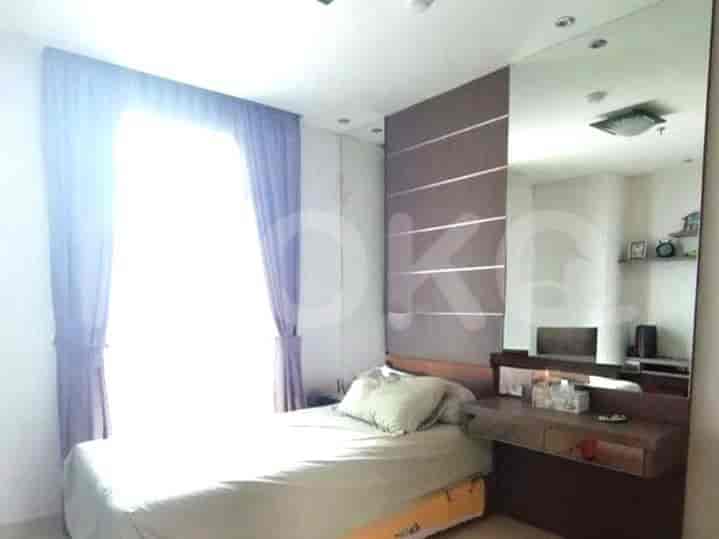 A bedroom with a single bed, a desk, and large window.