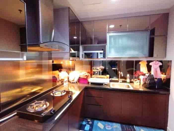 A modern kitchen with stainless steel appliances and dark wooden cabinets.