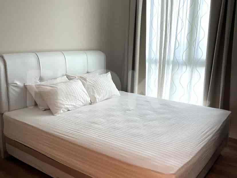 Kamar tidur dengan tempat tidur ganda, linen putih, dan gorden.