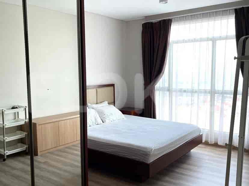 Kamar tidur dengan tempat tidur ganda dan lemari cermin.