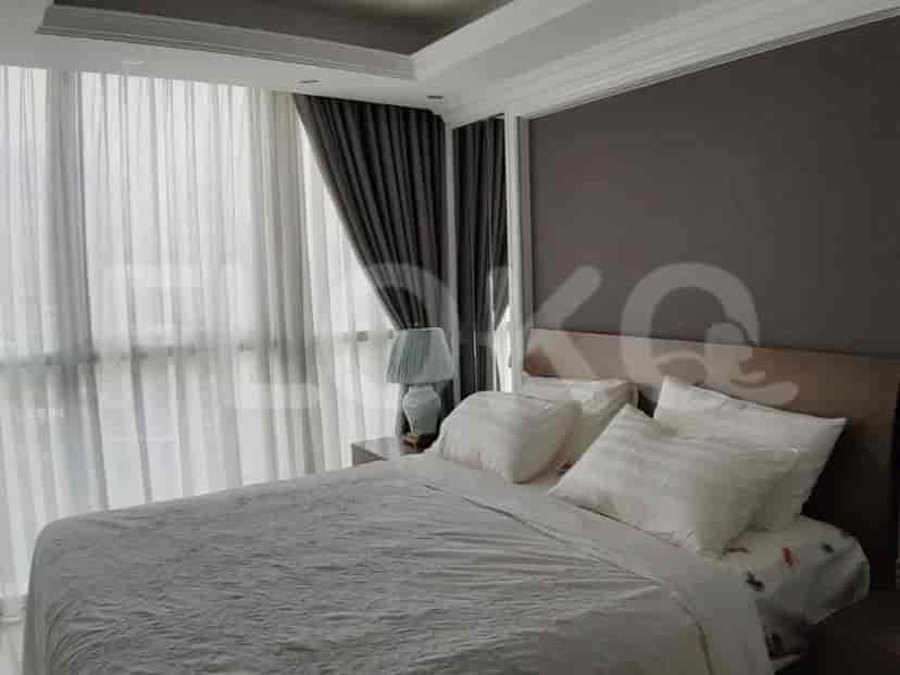 A bright and airy bedroom featuring a large bed and sheer curtains.