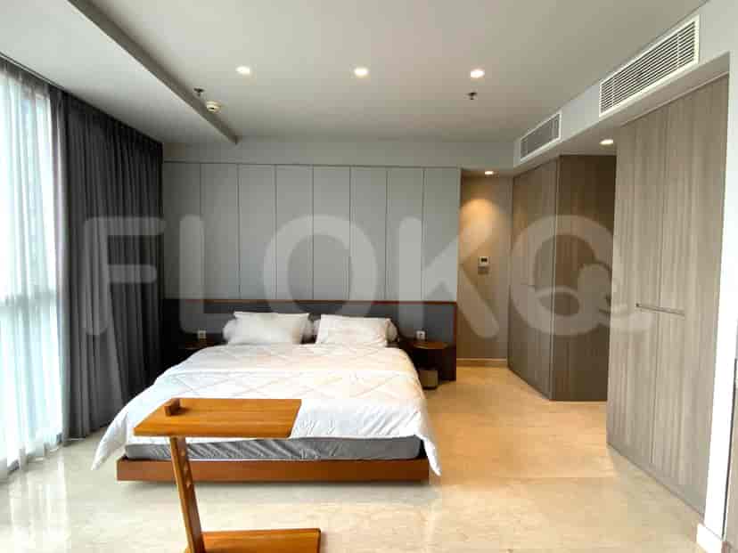 Modern bedroom with a large bed, wooden side table, and floor-to-ceiling windows.