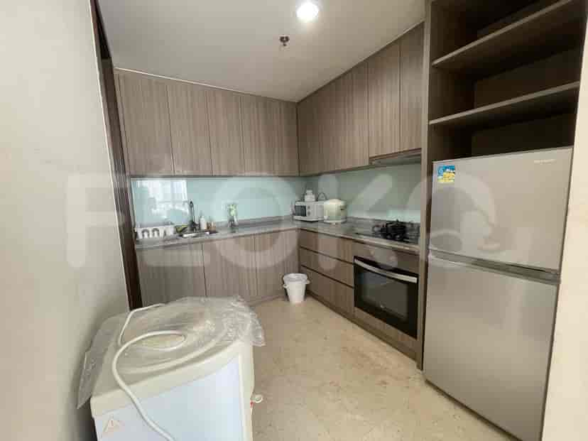 A modern kitchen with wooden cabinets, a refrigerator, and a stove.