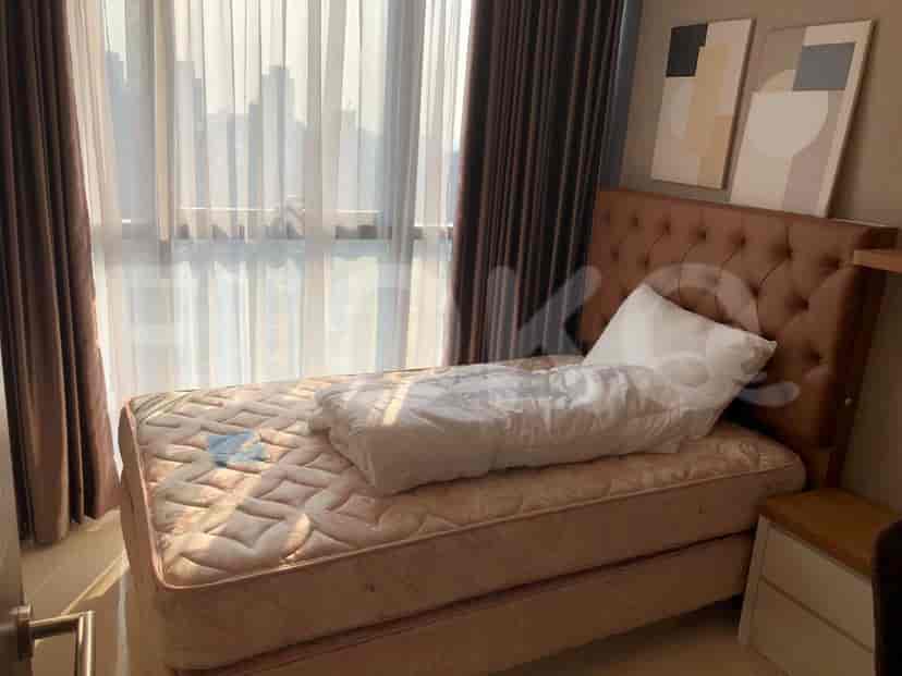 A bedroom with a single bed, featuring a headboard and large windows.