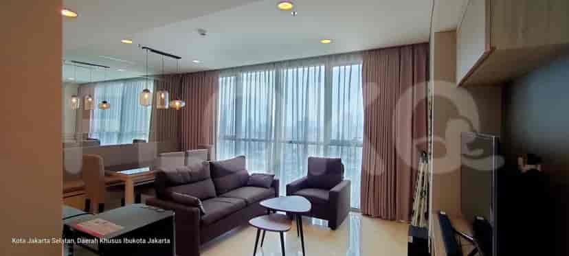 The living room and dining area, with a sofa, coffee tables and a large window with curtains.