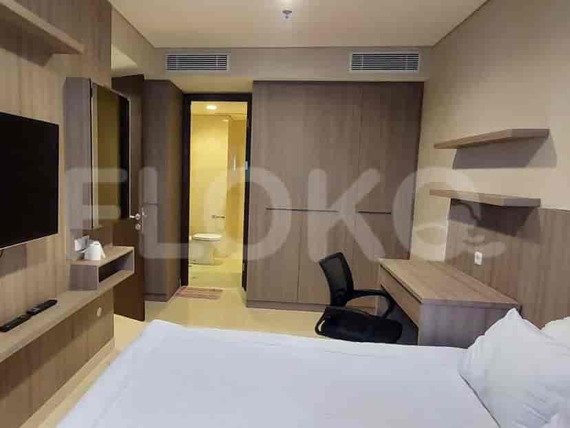 A bedroom with a working area, large wardrobe, and an attached bathroom.