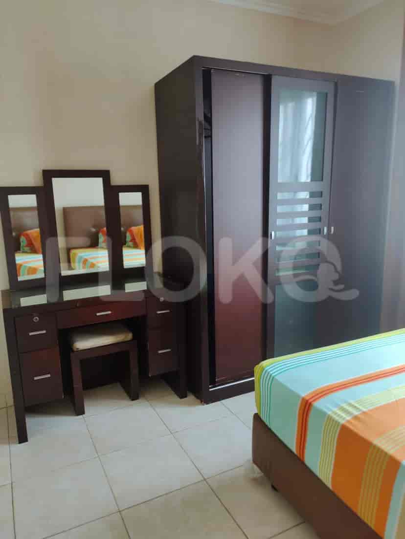 Bedroom with bed, dressing table, and closet.