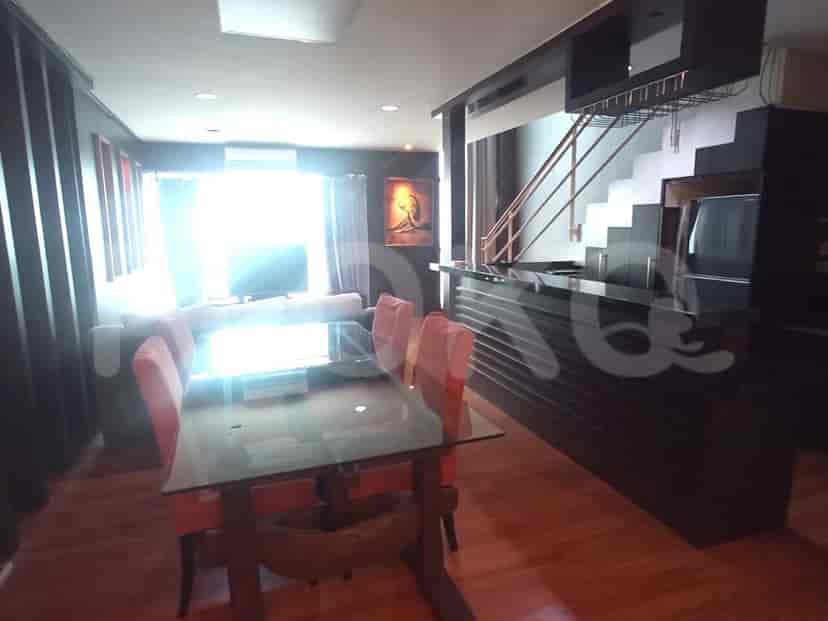 View of a living area and dining area with a staircase leading to the upper floor.