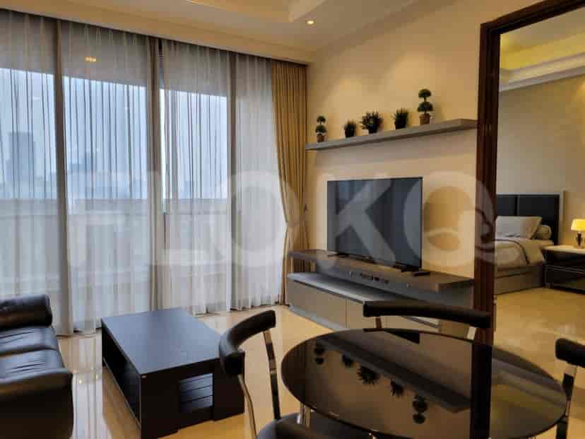 Living room with large windows, curtains, and a TV unit.