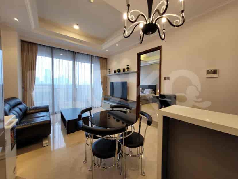Modern living room with a black leather sofa, round glass table, and city views.