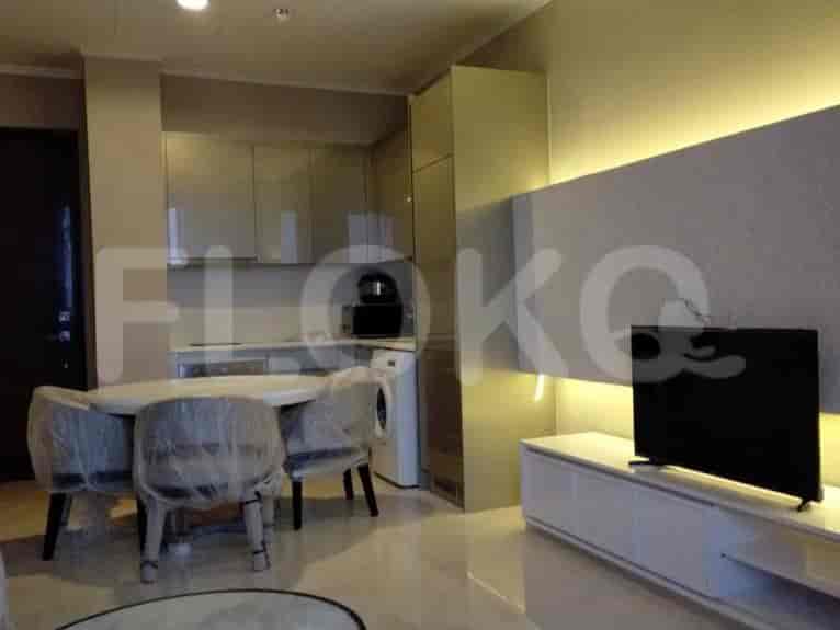A modern kitchen with a round dining table and chairs. The kitchen features sleek cabinetry, a built-in microwave, and a washing machine.