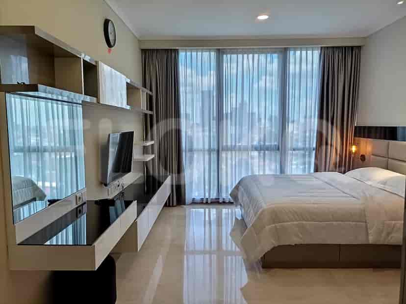 Modern bedroom with a bed, wall-mounted TV, and city view.