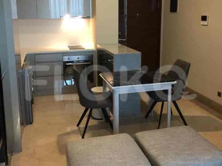 A modern kitchen with a dining area, featuring a marble countertop and two dining chairs.