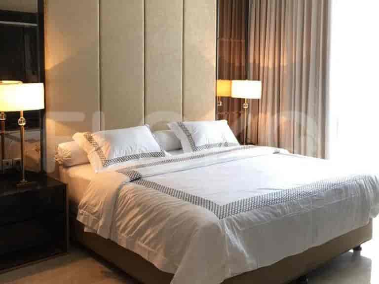 A well-lit bedroom with a large bed, bedside lamps, and curtains.