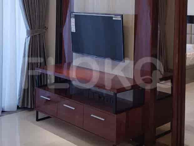 TV area with a wall-mounted TV and a wooden entertainment unit.