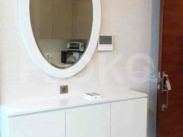 Entrance with a mirror, storage unit, and electronic panel.
