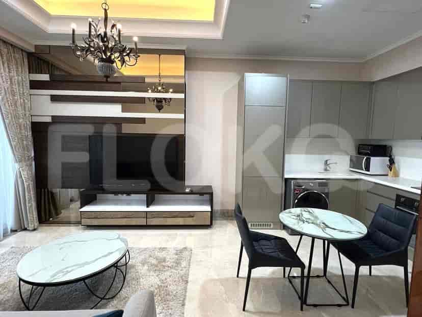 An open-plan living space with a dining area and a modern kitchen, featuring integrated appliances and stylish decor.
