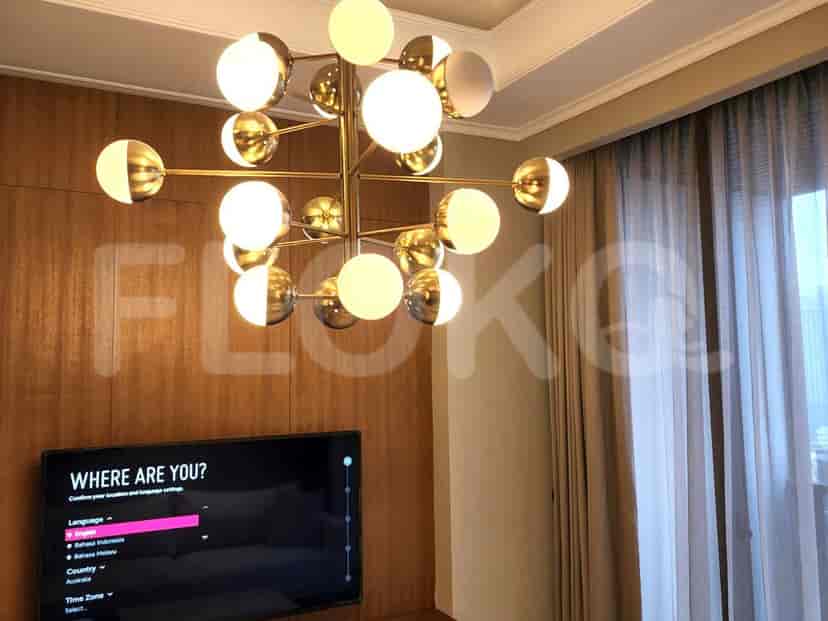 A living room with a chandelier and wall-mounted TV