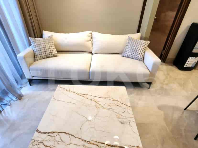 Living room with a cream sofa, marble coffee table, and decorative pillows.