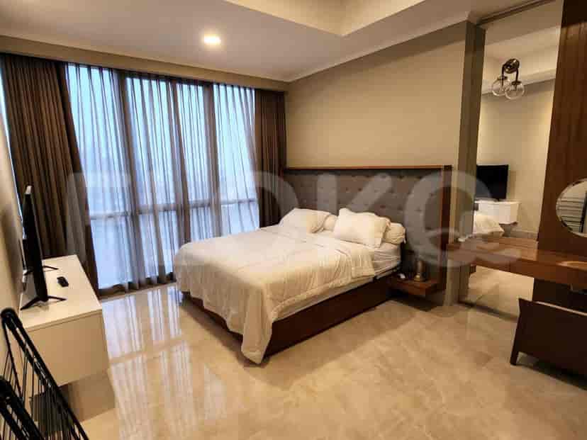 A spacious bedroom with a king-sized bed, large windows, and a dressing table.