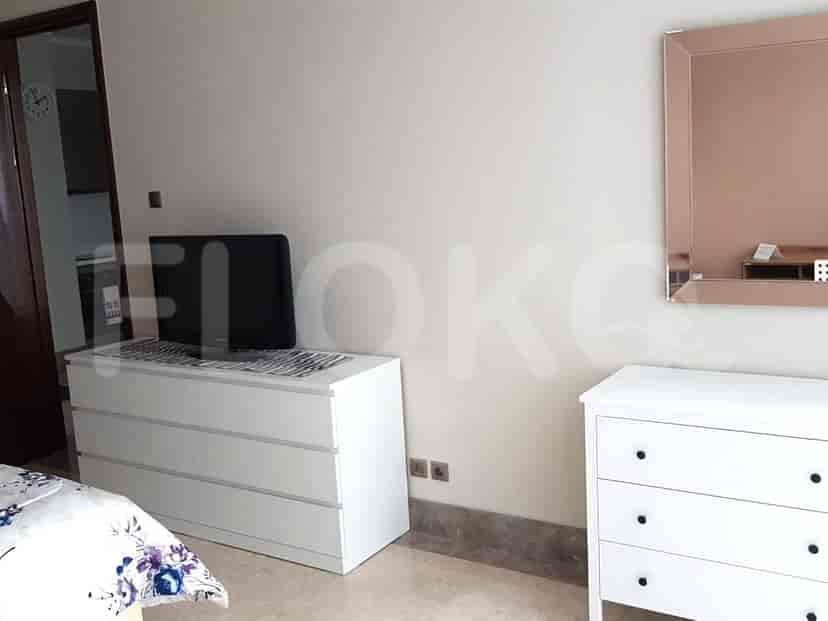 Bedroom with a bed, dresser, and access to a balcony.