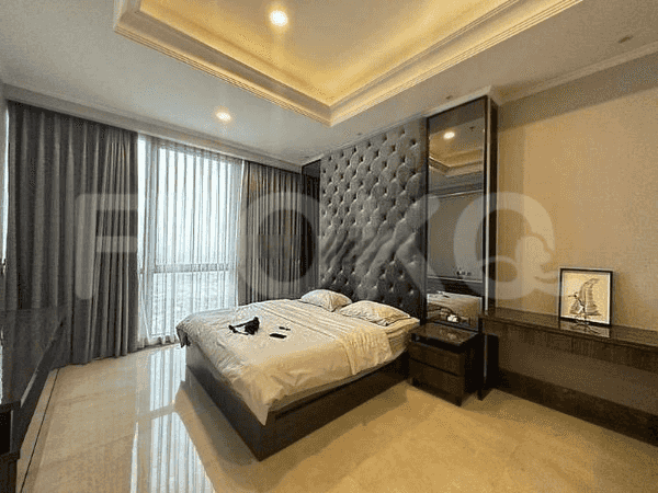 A luxurious bedroom featuring a large bed with tufted headboard, mirror, and a spacious design.