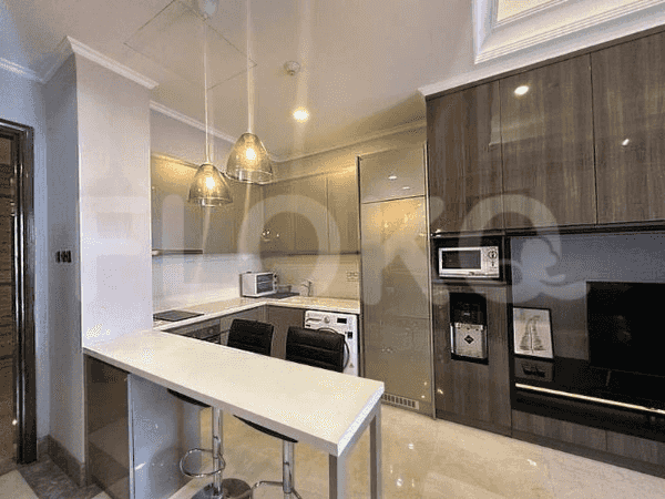 Modern kitchenette with cabinetry, cooking appliances, and bar seating.
