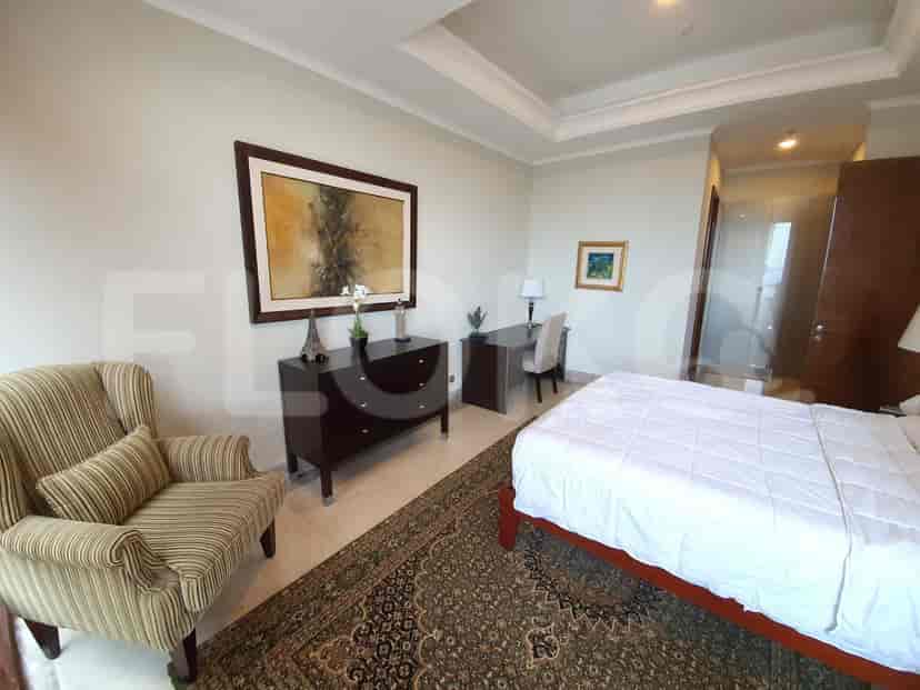 Bedroom with bed, armchair, and desk.