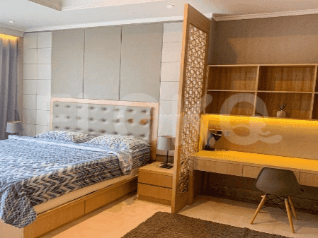 Elegant bedroom with a king-size bed, wooden desk, and stylish room divider.