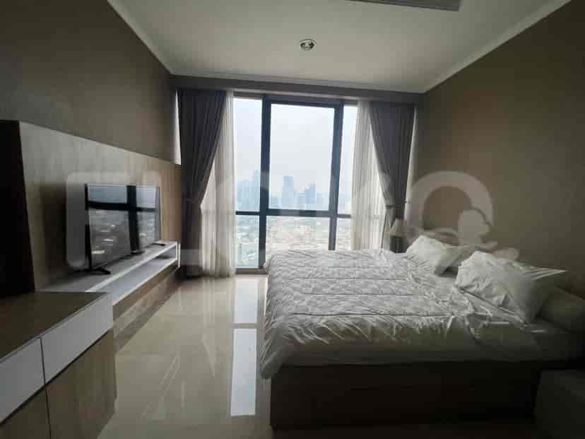 Another bedroom featuring a king size bed, and a wall mounted TV with a city view.